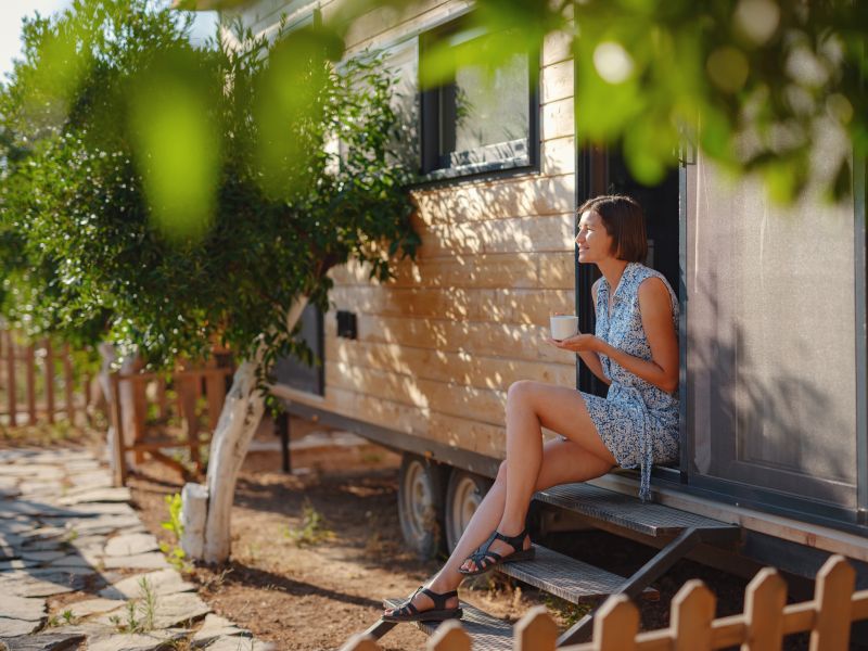 tiny home comfort with woman on steps of home